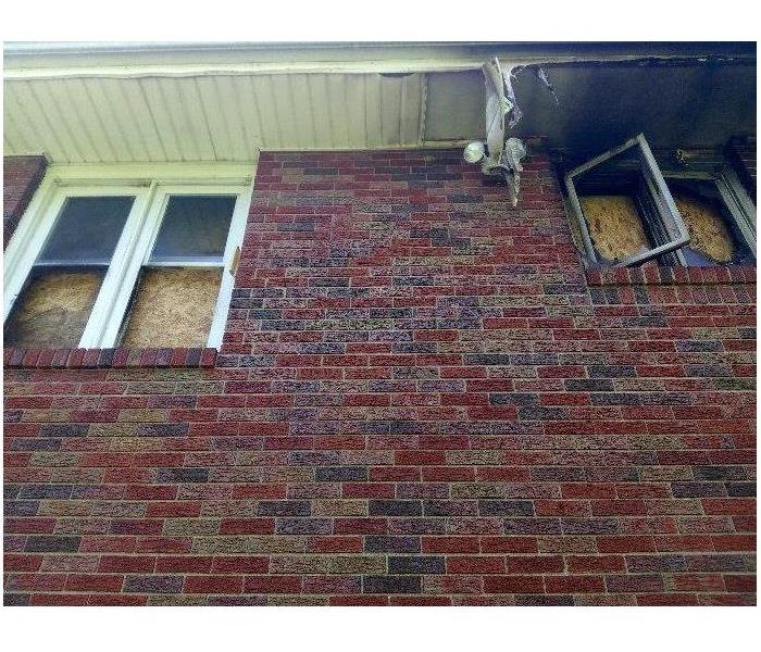 image of brick home after fire damage with windows destroyed and gutter damage