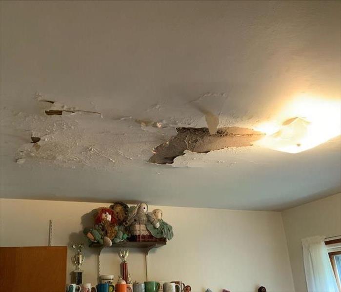 A bedroom ceiling is damaged from water.