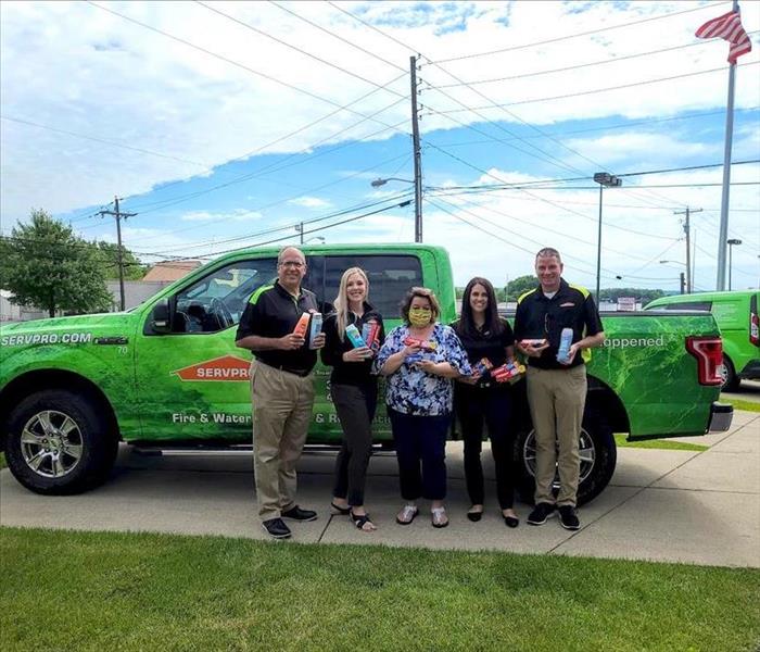 image of servpro employees holding items to be donated to a local charity