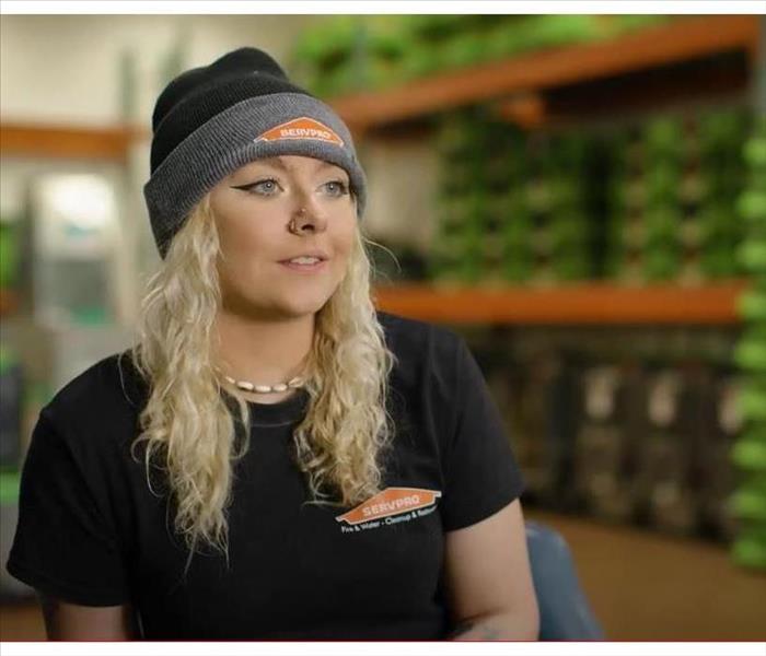 female SERVPRO employee sitting in warehouse in front of equipment