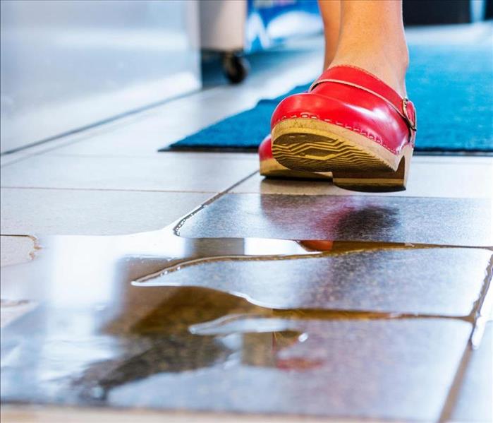 water on tile floor and woman walking