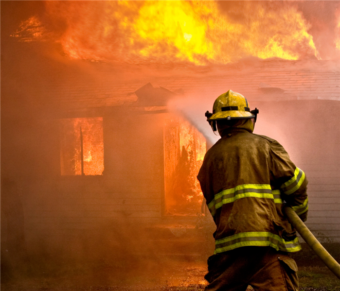 Firefighter putting out housefire.